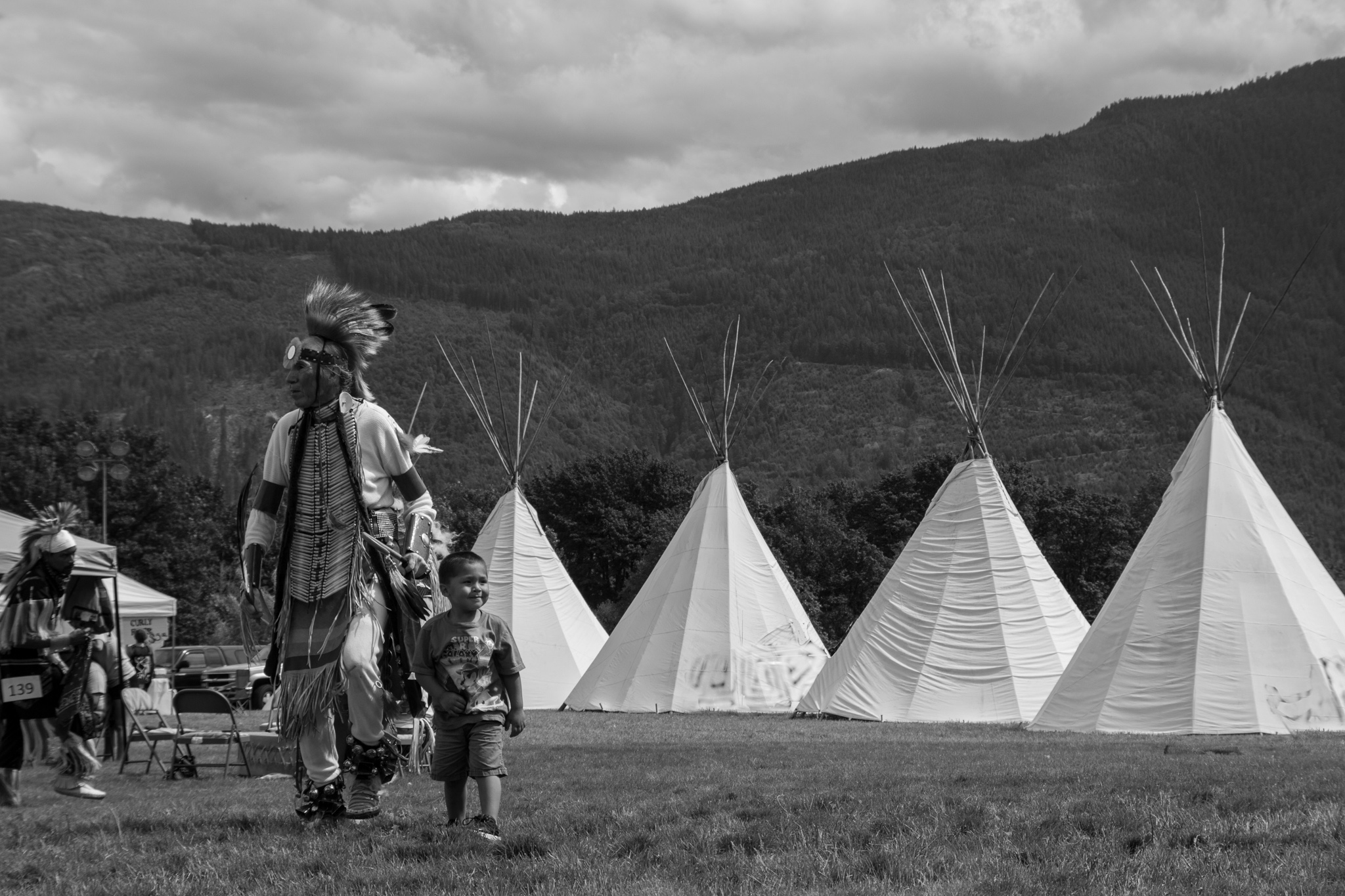 Native elder and child at teepees